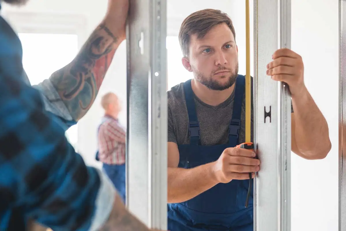 Garage Door Business Consulting 3 Technician measuring frame for installation reflecting planning and precision in garage door business consulting